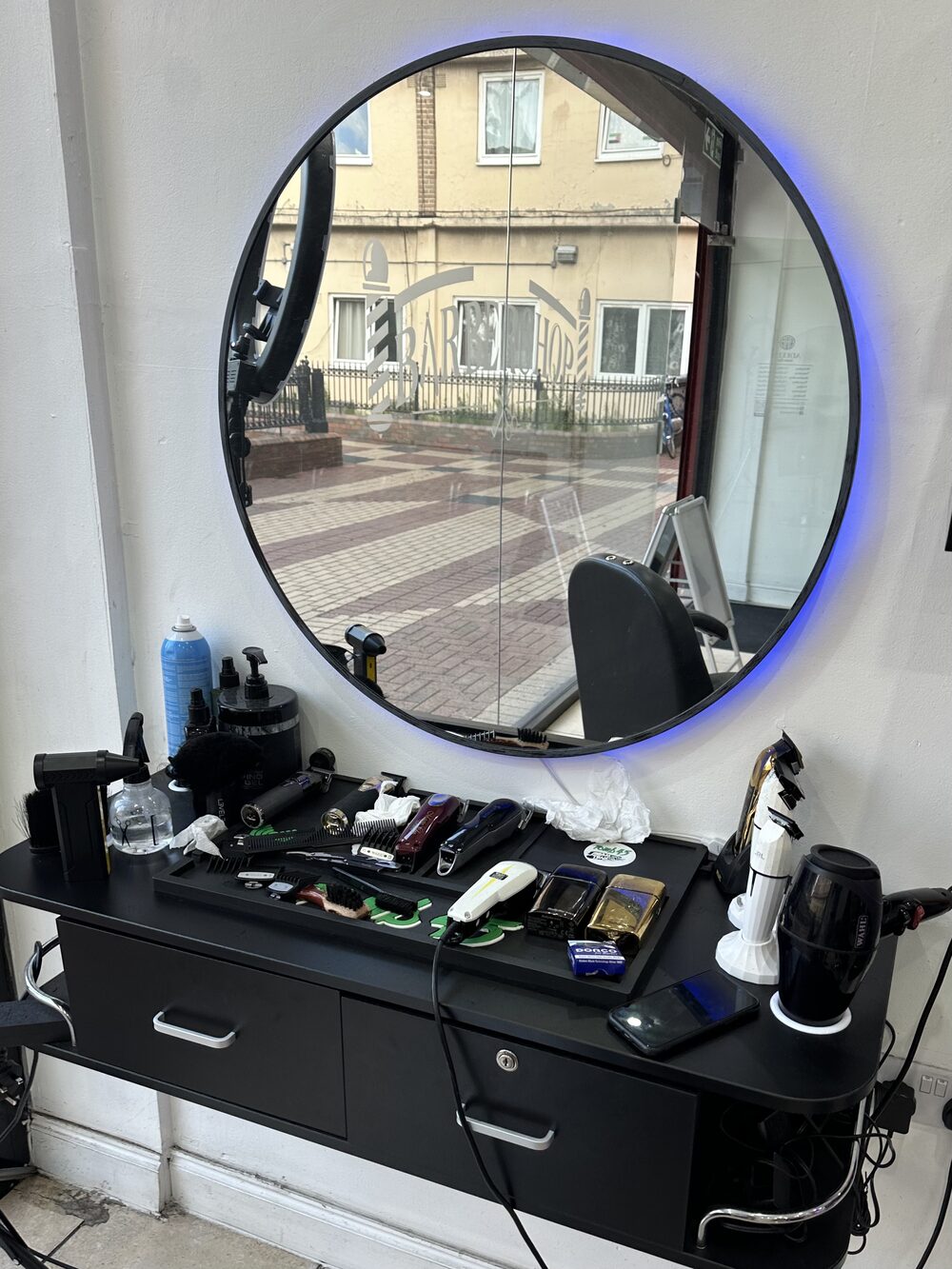 Circular LED mirror at Adeel's Barbershop